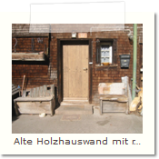 Alte Holzhauswand mit reparierter Tür